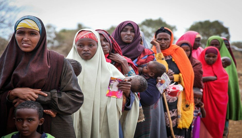 Women and children queue to enter a free medical clinic